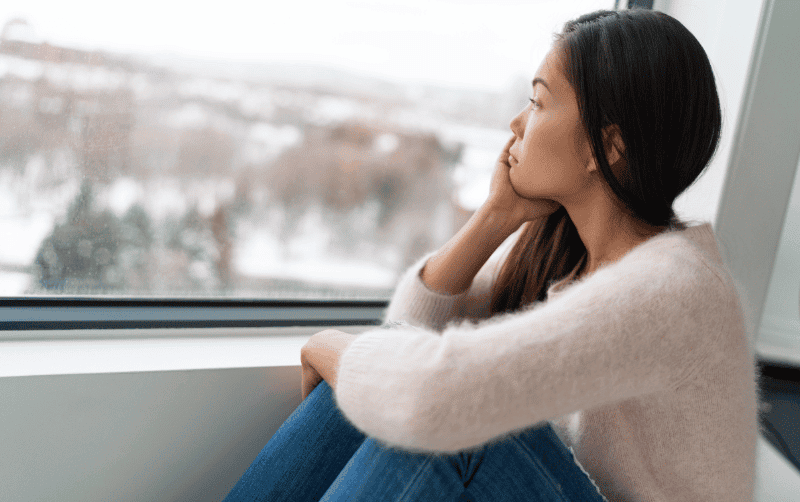 Contemplative woman gazing out window